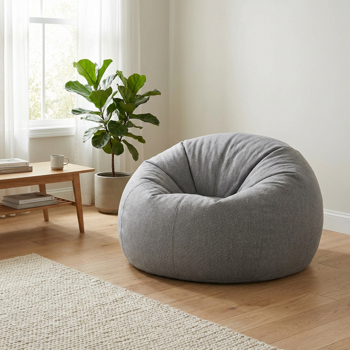 Grey bean bag chair, full and plump after refilling, in a bright living room